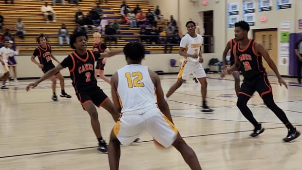 Hattiesburg's Christian Moody sizes up two West Harrison defenders in the Tigers' 72-42 playoff win over the Hurricanes Saturday in Hattiesburg.