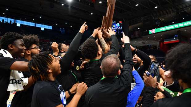 Lutheran East players and coaches hoist the OHSAA Division III state championship trophy.