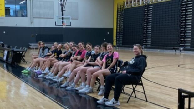 Katie Smith poses on the bench with the Upper Arlington girls basketball team. Smith has been serving as a volunteer assistant coach o for the Golden Bears.