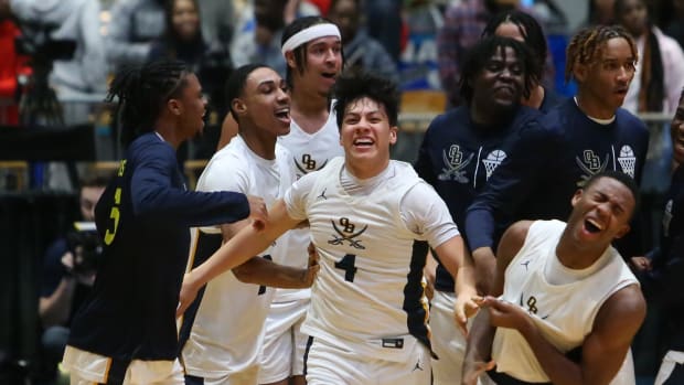 The Olive Branch basketball team mobs Zahir Gutierrez after the senior hit a buzzer-beating three-pointer in overtime to send the Conquistadors to the MHSAA Class 6A Championship on Feb. 28, 2024 at the Mississippi Coliseum.