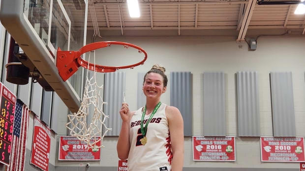 Loudonville's Corri Vermilya poses with her piece of the net after winning an OHSAA Division IV district final on Saturday, March 2, 2024.