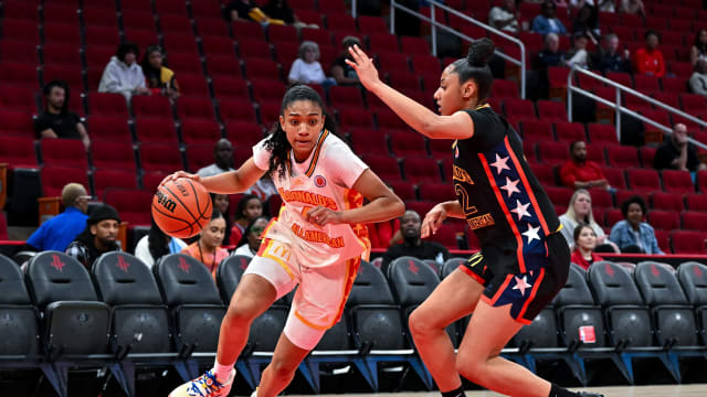 McDonald's All American East forward Riley Nelson (4) drives around McDonald's All American West guard JuJu Watkins (12) during the first half at Toyota Center.