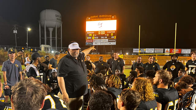 Oak Grove coach Drew Causey applauds his defense for the goose egg after the Warriors' 49-0 win over Wayne County in the 2023 MHSAA season opener.