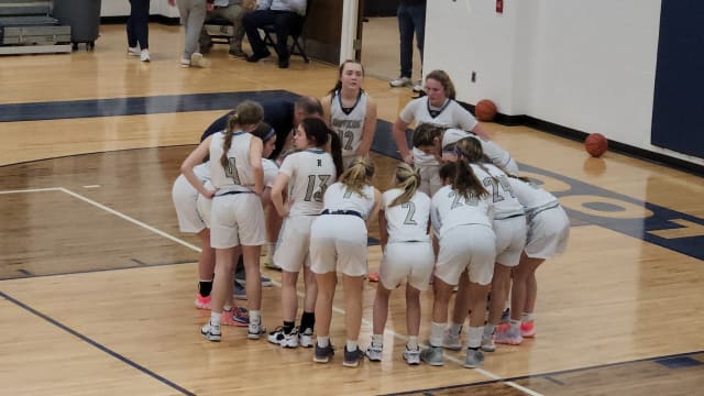 Rootstown players huddle around head coach Joe Leonard for final instructions prior to a game against Kirtland on January 29, 2024.