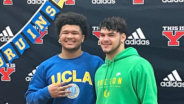 Yelm High School's Isaiah Patterson (UCLA), left, and Brayden Platt (Oregon) sign their national letters of intent in the early signing period Wednesday in the school gymnasium.