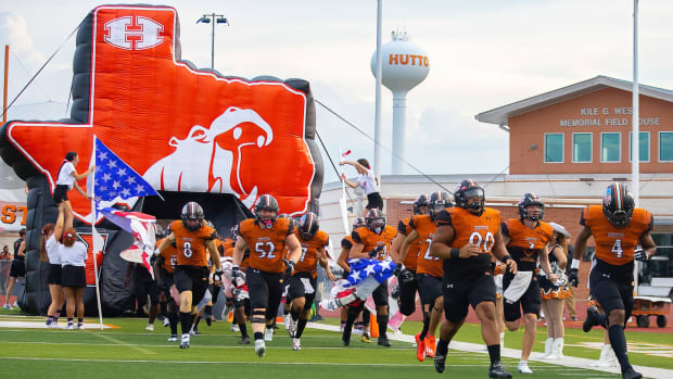 The Hutto football team crashes through a Texas-sized Hippo banner.