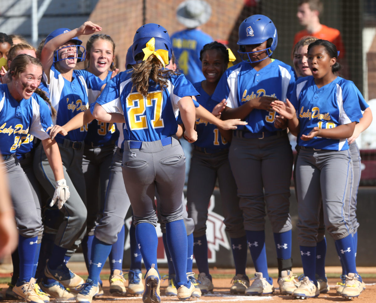 Teammates greet Booneville High School's Olivia Garrett (27) after she hit a home run. Booneville and Raleigh played in game two of the MHSAA Class 3A Baseball Championship at Mississippi State University on Thursday, May 13, 2021. Photo by Keith Warren