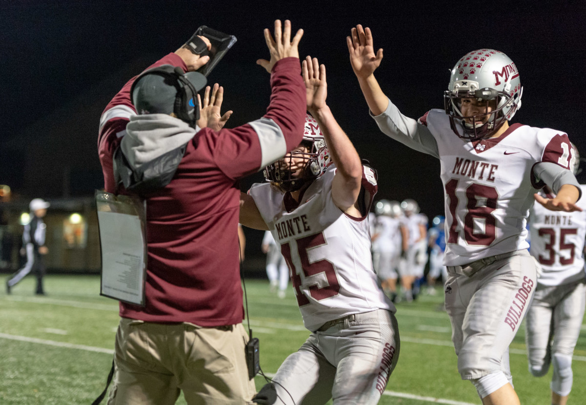 Montesano coach Matthew Jensen high fives Jared Whisenbhunt and Jacob Salstrom after a first-quarter touchdown in a 1A Southwest District playoff game on Friday, Nov. 5, 2021, at Beaver Stadium in Woodland. Montesano won 42-20. (Joshua Hart/For ScorebookLive)