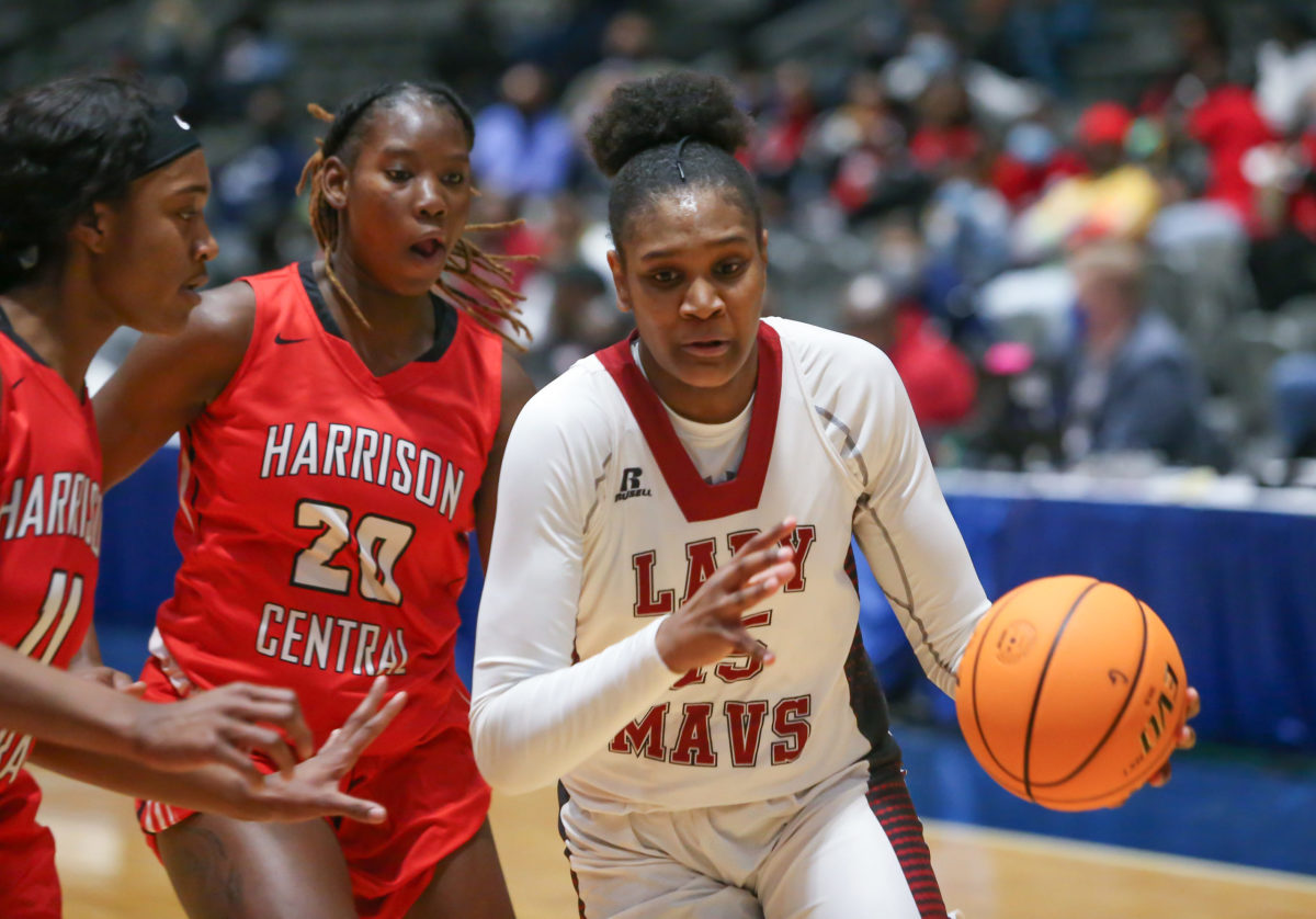 Germantown's Madison Booker (15) drives to the basket as Harrison Central's JeMya Evans (20) and Harrison Central's Dekeria Walls (11) defend. Germantown and Harrison Central played in an MHSAA Class 6A basketball semifinal basketball game at Mississippi Coliseum on Wednesday, March 3, 2020. Photo by Keith Warren