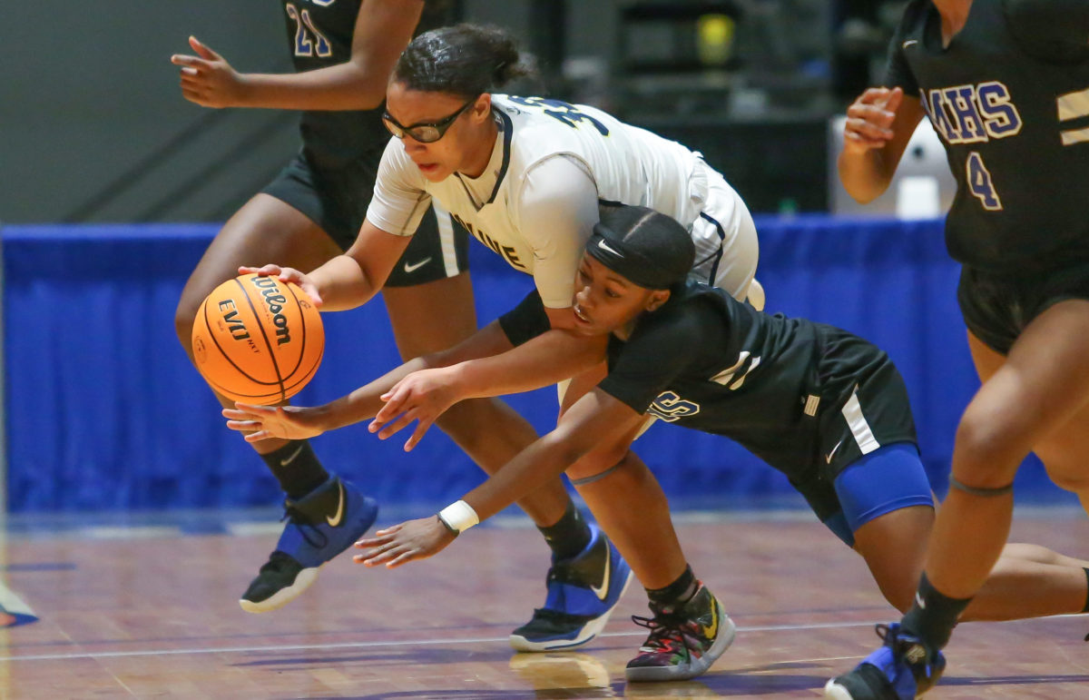 Olive Branch's Rhema Pegues (32) and Meridian's Jamyia King (1) fight for control of the basketball. Meridian and Olive Branch played in an MHSAA Class 6A basketball semifinal basketball game at Mississippi Coliseum on Wednesday, March 3, 2020. Photo by Keith Warren