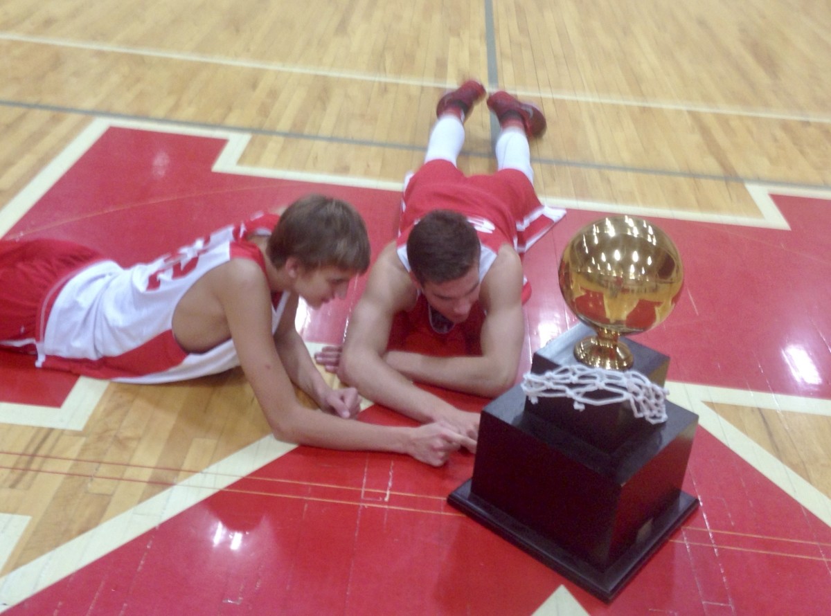 Kispert and a teammate pose in the King's High School gym with the 1A state championship trophy.