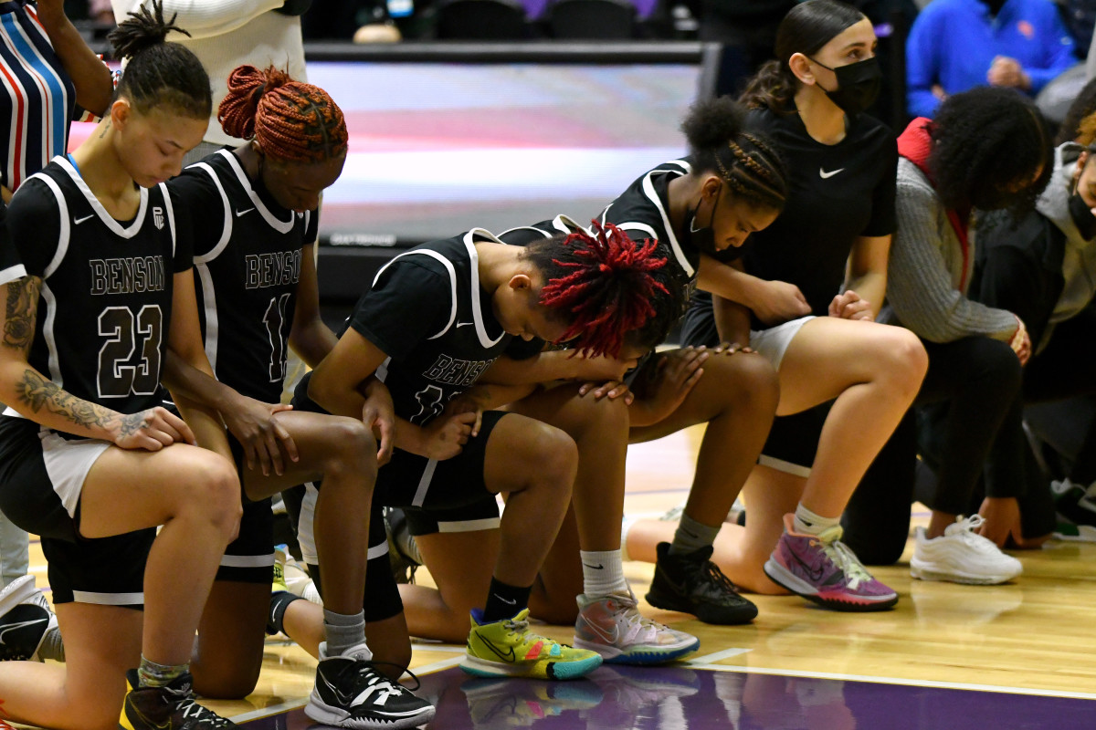 Benson girls basketball team locks arms in prayer.