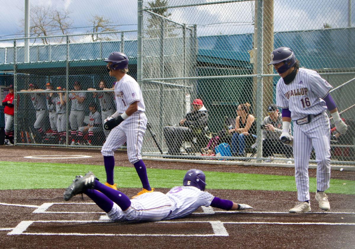 Puyallup outfielder Noah Fields dives into home during the Vikings' bi-district semifinal win over Camas at Kent-Meridian High School.