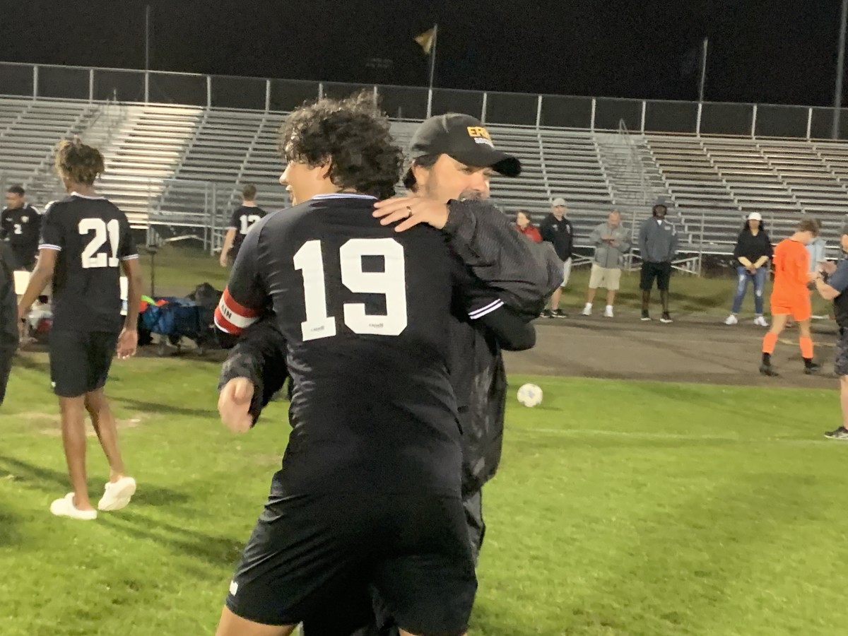 East Ridge coach John Quirk hugs defender Jackson Sandoval after the Knights' 3-1 victory over Timber Creek in a Class 7A, Region 1 semifinal.