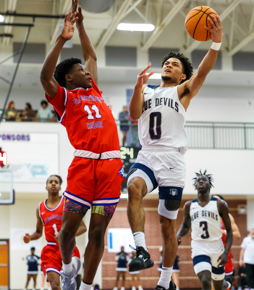 Against the strong defense of Peachtree Ridge's Milz Tatum, Norcross' Bilal Abdur-Rahman makes a strong move to the rim with his left hand.