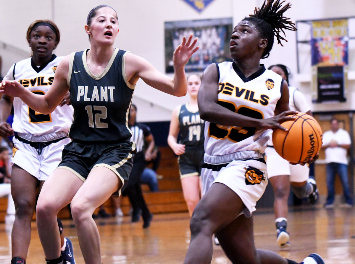 Winter Haven senior guard Bre'Asia Washington heads in for a basket while Tampa Plant forward Morgan Sieper during Class 7A, Region 3 final on Friday at Winter Haven.