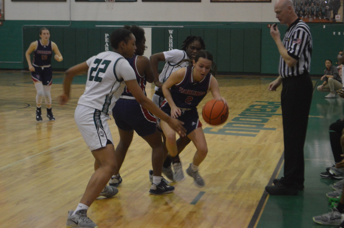 Teurlings Catholic's Kennedy Sinitiere (2) tries to dribble through Peabody's Demariah Lavan (22) and Aveonna Glasper (back) during Monday's Division II select regional playoff game at Peabody.
