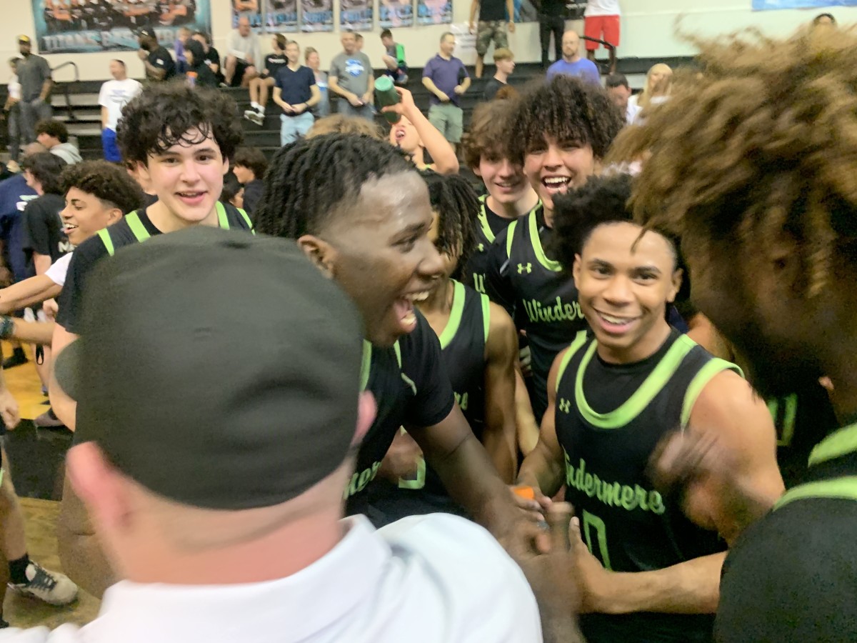 Windermere guard Isaiah Dorceus shouts in exultation as he celebrates the Wolverines' 66-51 win over Olympia with Ta'Veon Jones (0) and the rest of his teammates.