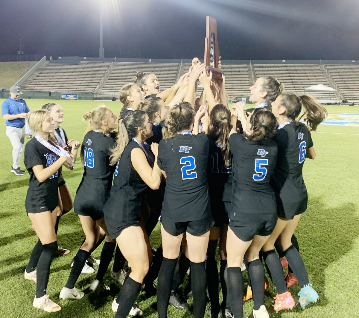 Bartram Trail midfielder Malia Roberts lifts the 7A girls championship as her teammates celebrate their 3-0 victory over Boca Raton.