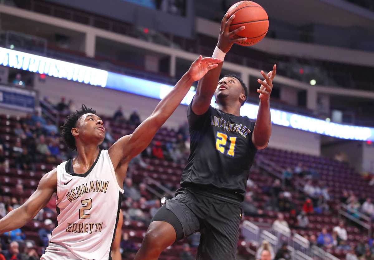 Lincoln Park's Dorian McGhee (21) goes for a layup while being guarded by Neumann-Goretti's Robert Wright (2) during the first half of the PIAA 4A Championship game Thursday night at the Giant Center in Hershey, Pennsylvania.