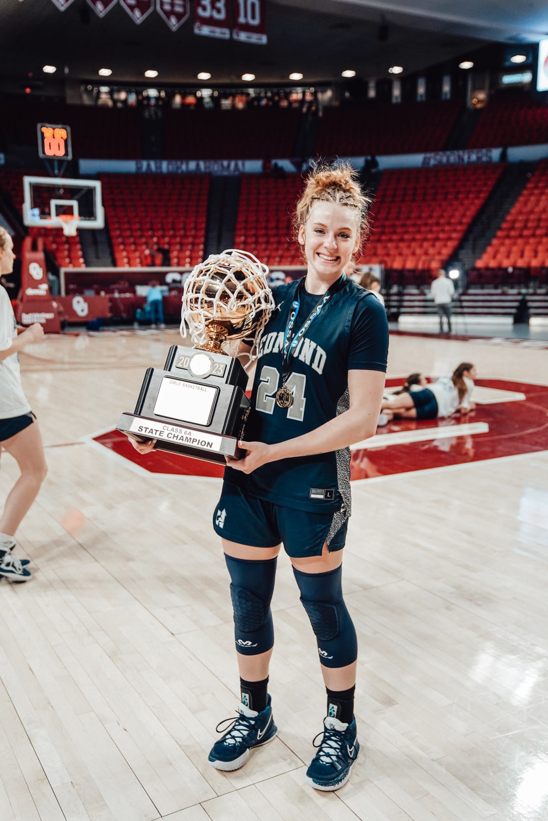 Edmond North's Laci Steele hoists the 6A state championship trophy after the Lady Huskies repeated as 6A champions in March.