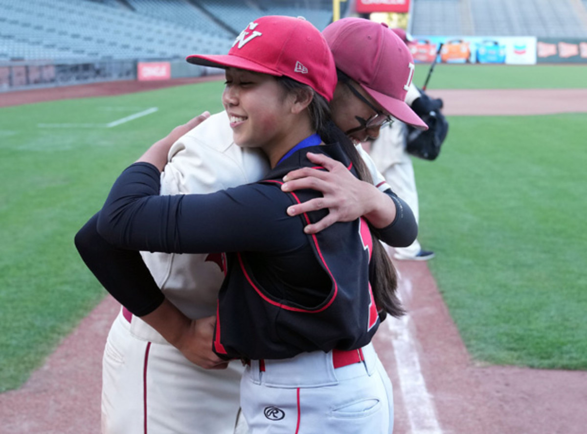 Roman and Isabella embraced at home plate after last year's game. Photo: Darren Yamashita. 