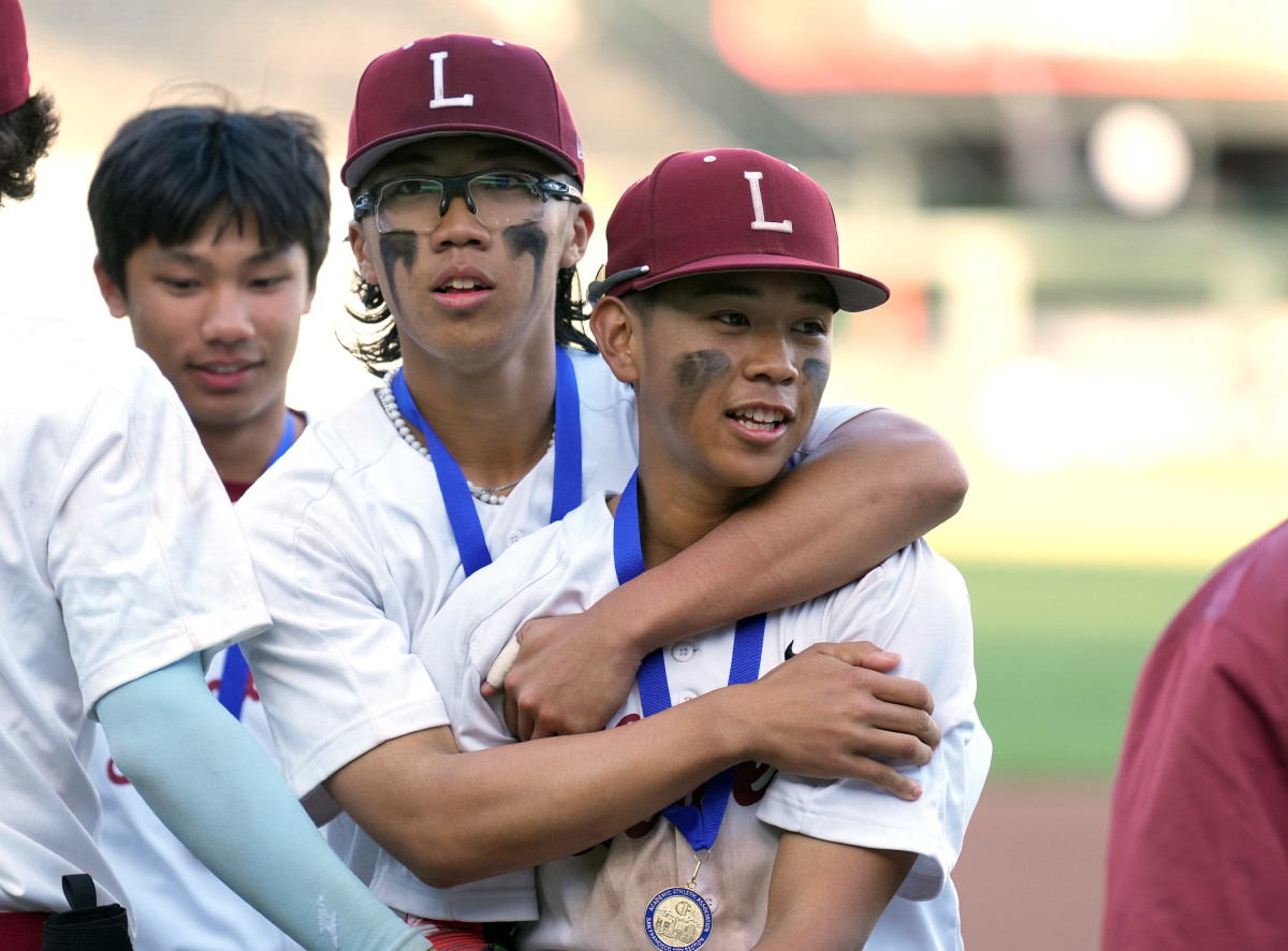 Roman Fong wraps his arms around his younger brother Reggie after Lowell's 11-3 win over Washington at Oracle Park. Photo: Darren Yamashita. 