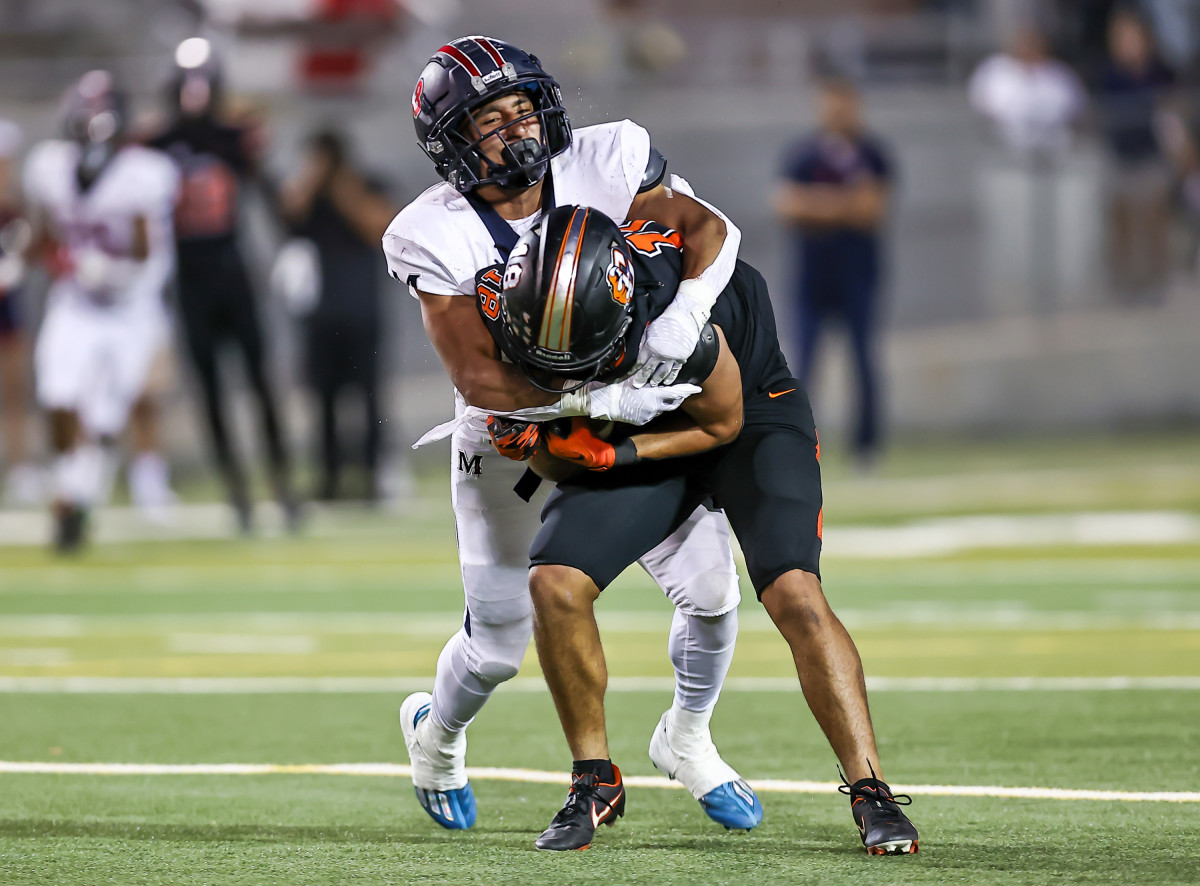 A San Joaquin Memorial defender tries to bring down Central Grizzlies receiver Braylen Hall. (Photo by Bobby Medellin)