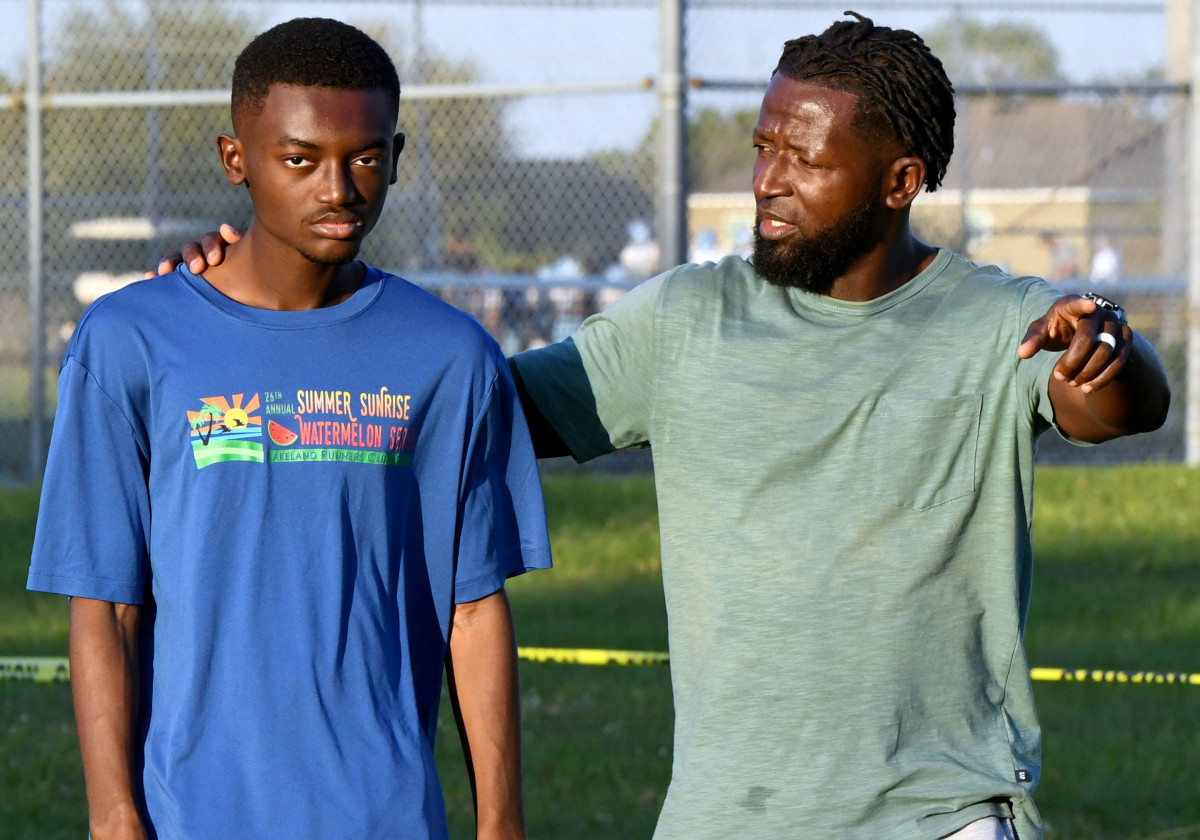Lake Region senior cross country runner Israel Mirtil receives instruction from his father Pheto Mirtil during a workout Thursday evening at Lake Region High School. Mirtil, who is autistic, will have to run a course that has changed considerably because of the destruction left from Hurricane Ian this past week.