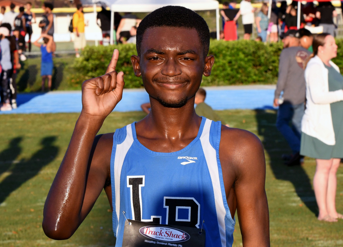 Lake Region senior Israel Mirtil holds up the No. 1 finger after winning the Polk County cross country meet on Saturday at Lake Region High School.