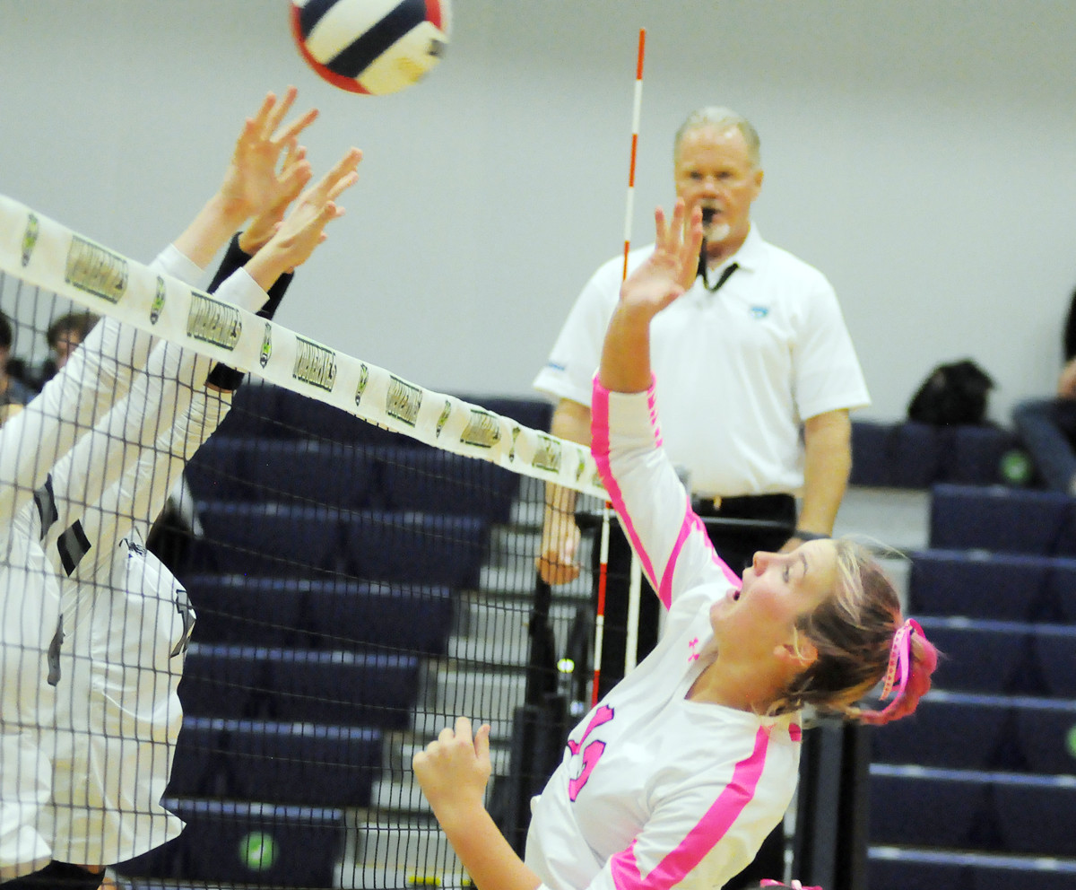 Windermere middle blocker Annie Frost (13) goes for an attack against Lake Nona's Ella McDonald and Emma Gongora.