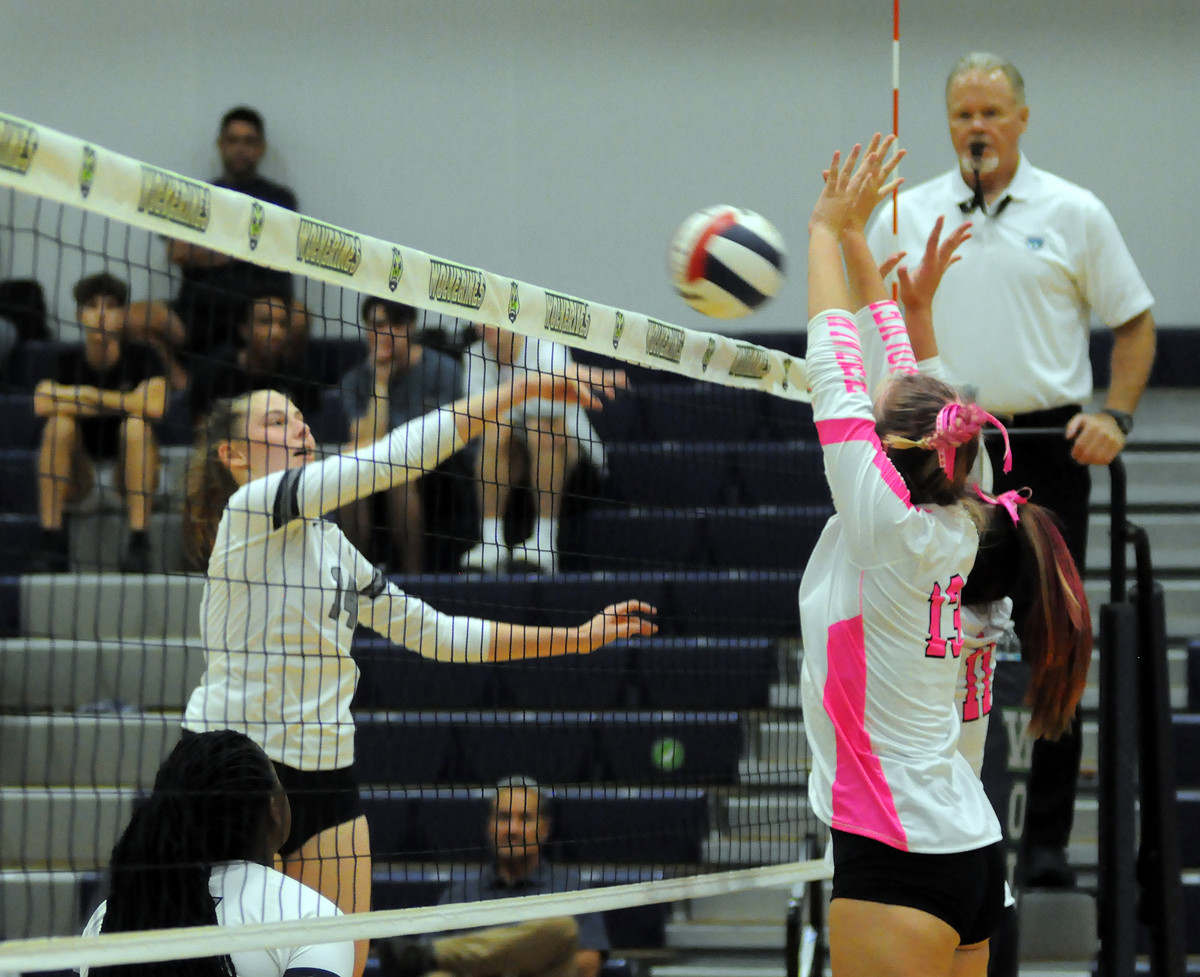 Lake Nona's Anna Pantano (14) goes for a kill against Windermere blockers Annie Frost (13) and Isabel Mulita (11) during the Lions' victory on Thursday.