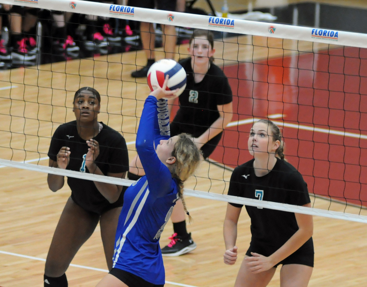 THE GREAT CHESS MATCH - setter vs. blockers. Barron Collier setter Ava Zehnder tries to set against Jensen Beach blockers Kiosha Smith (1) and Catherine Hamilton (7) during their Class 5A volleyball final.