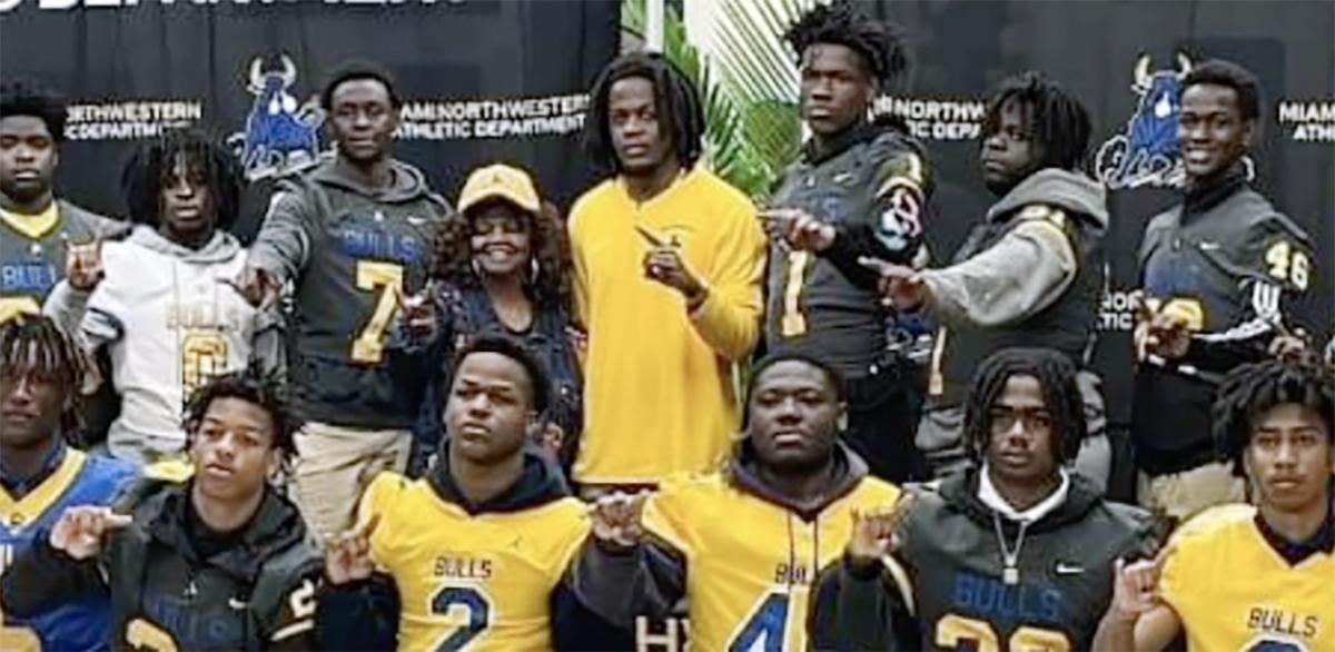 Former NFL quarterback and South Florida native Teddy Bridgewater (center) flashes the No. 1 sign with several of his players, shortly after being announced as the new head football coach at Miami Northwestern High School, his alma mater, Friday morning.