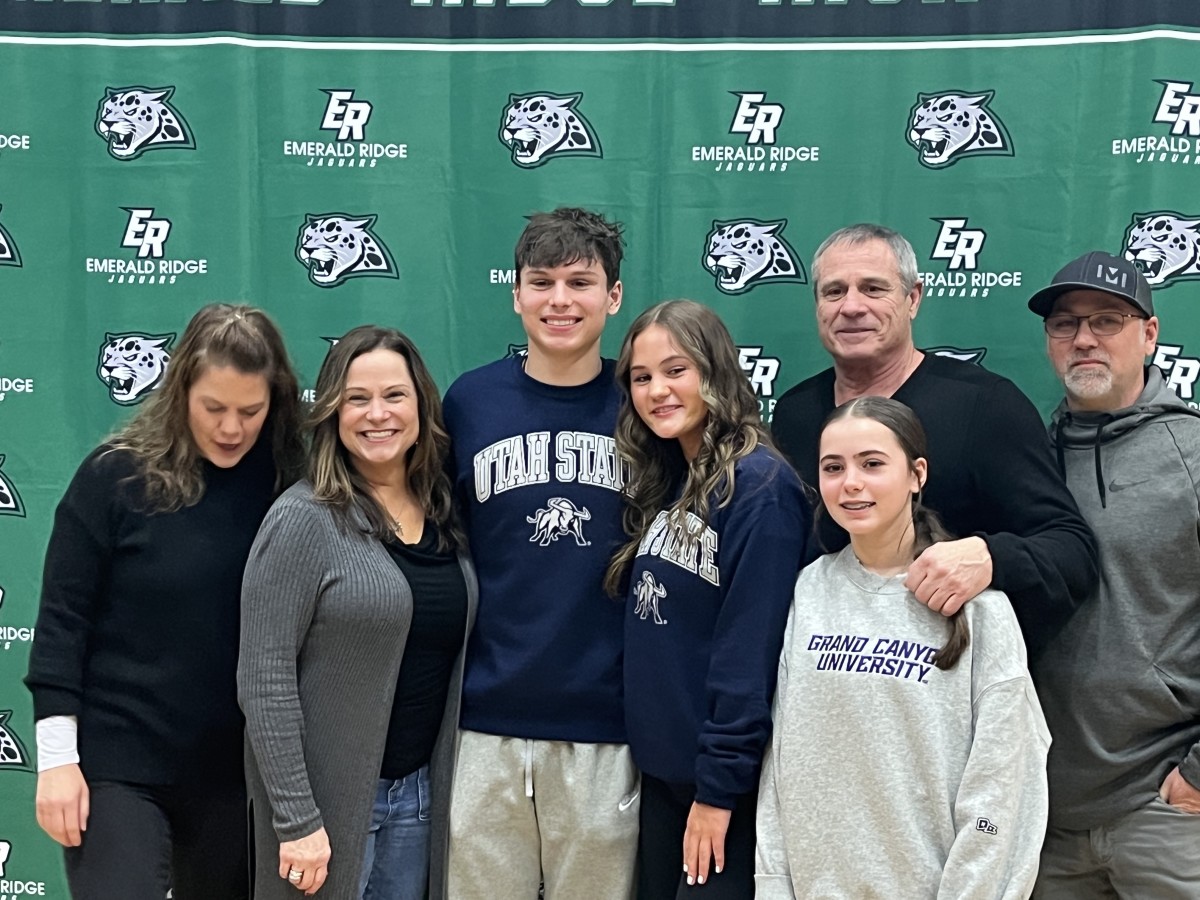 Emerald Ridge's Gio Kafentzis signs with Utah State (PWO) and poses with family for photo at National Signing Day on Wednesday in school gymnasium.