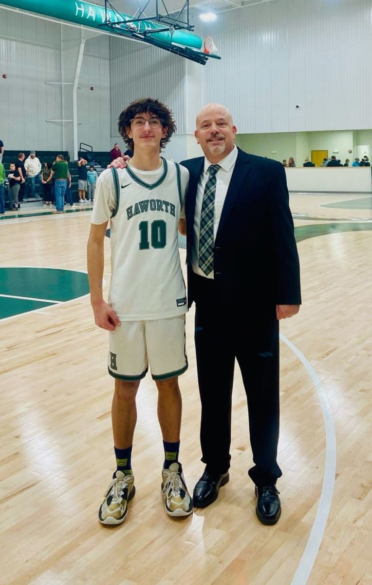 Haworth's Zayne Clampet (10) poses with his coach, Jeff Weedn, after Clampet hit 11 of the Lions' 27 3-point baskets, a new state record, after Haworth's win against Foreman (Ark.) on Feb. 9, 2024.