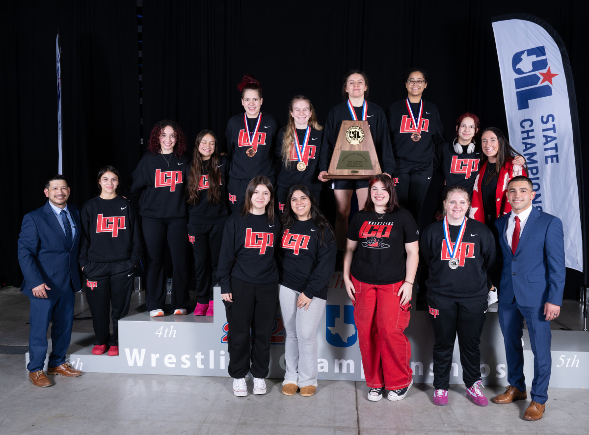 The Lubbock Cooper girls wrestling team poses with their first place medals after winning the UIL Class 5A girls wrestling state title.