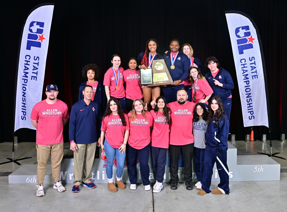 The Allen girls wrestling team poses with the 6A state trophy for the fourth straight year.