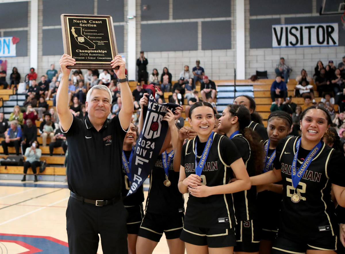 Stephen Pezzola holds up the North Coast Section championship plaque — the Pride's eighth since he took over in 2008-09 — after the team's 56-48 win over California for the D1 crown Saturday at Dublin High.