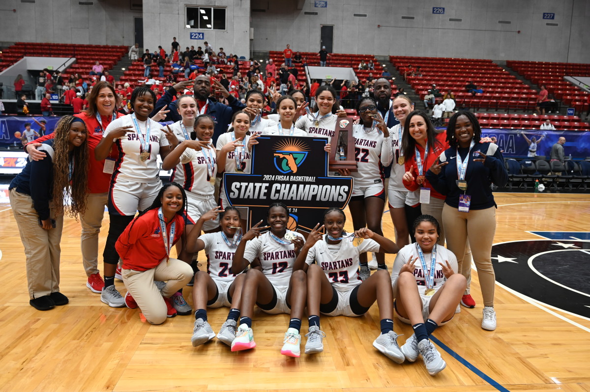 Miami Country Day players gather around their trophy after winning the  Class 3A state championship at the RP Funding Center in Lakeland on Friday. 