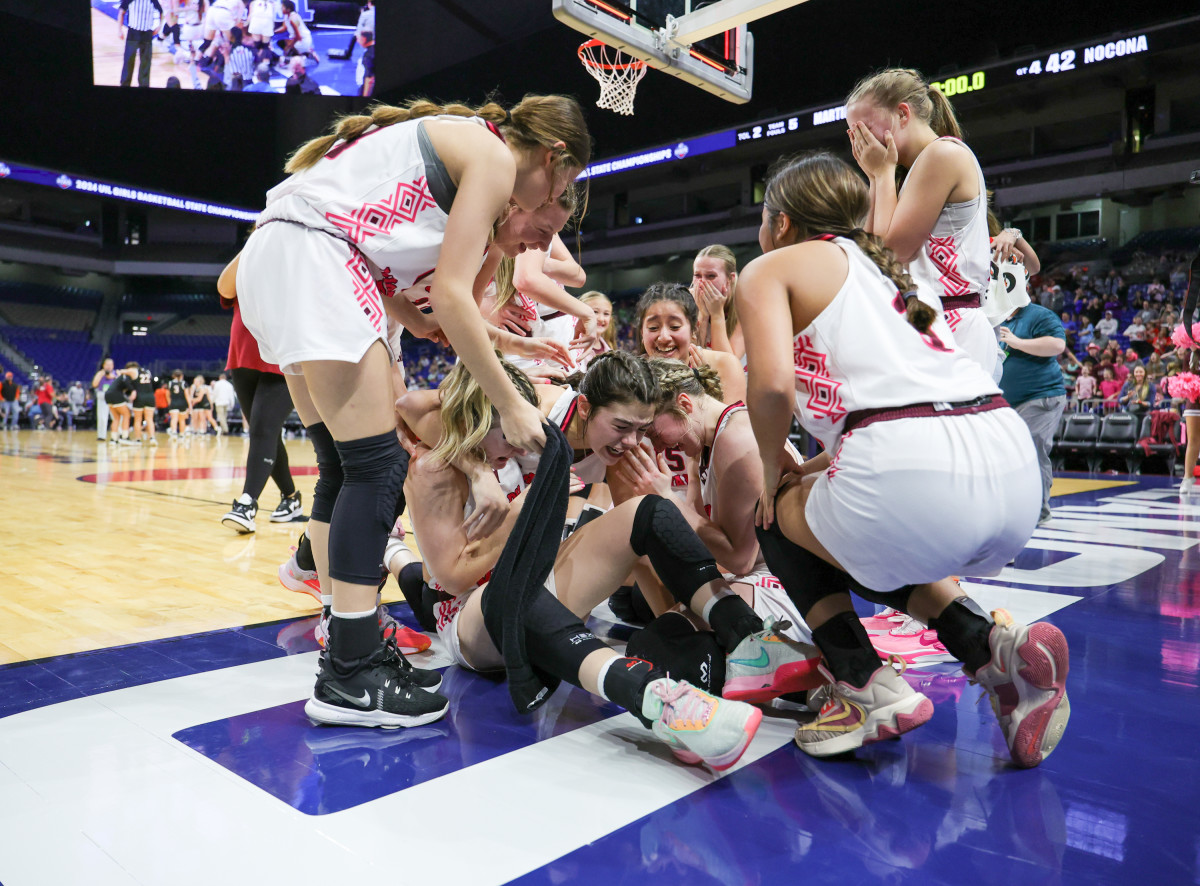 Martin's Mill players swarm Kara Nixon in celebration after she hit the game-winning shot to beat Nocona 44-42 in the UIL Class 2A state girls basketball championship on Saturday at the Alamodome.