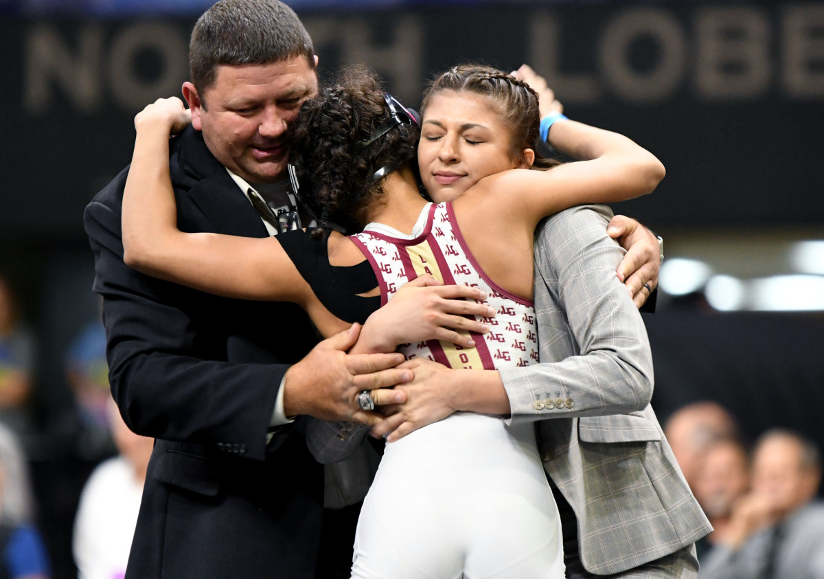 Lake Gibson senior Gabby Tedecso hugs coaches Briana Kellin and Danny Walker after winning the girls 106-pound wrestling state championship on Saturday at Silver Spurs Arena in Kissimmee. It was the second straight state title of her career. 
