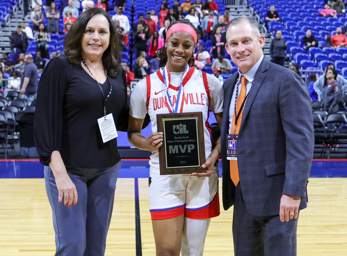 Mariah Clayton (center) poses with the Class 6A state championship MVP award after Duncanville raced past South Grand Prairie.