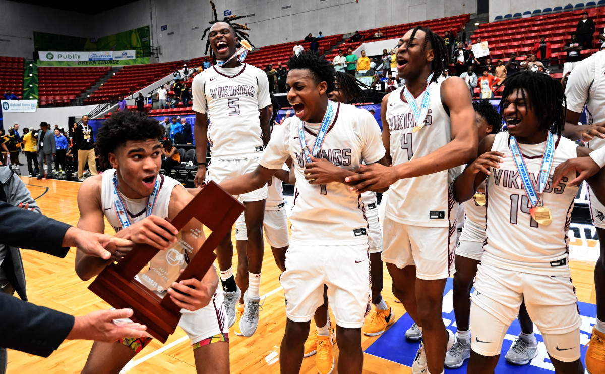 Miami Norland players celebrate after receving the Class 5A state championship basketball trophy on Friday after beating Tampa Blake for the title at the RP Funding Center.