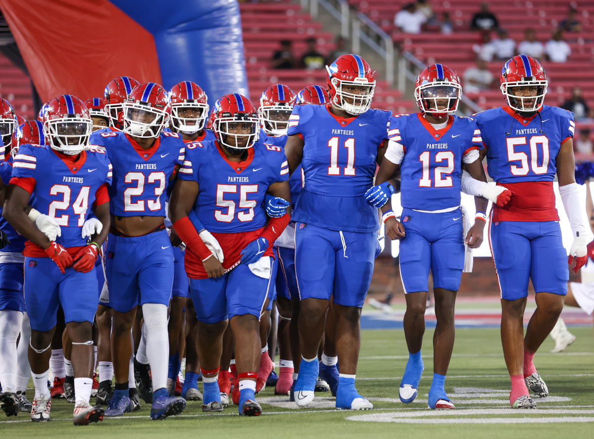 Behemoth defensive tackle Alex January (11) leads Duncanville onto the SMU Stadium turf for its season debut against South Oak Cliff on Aug. 25.