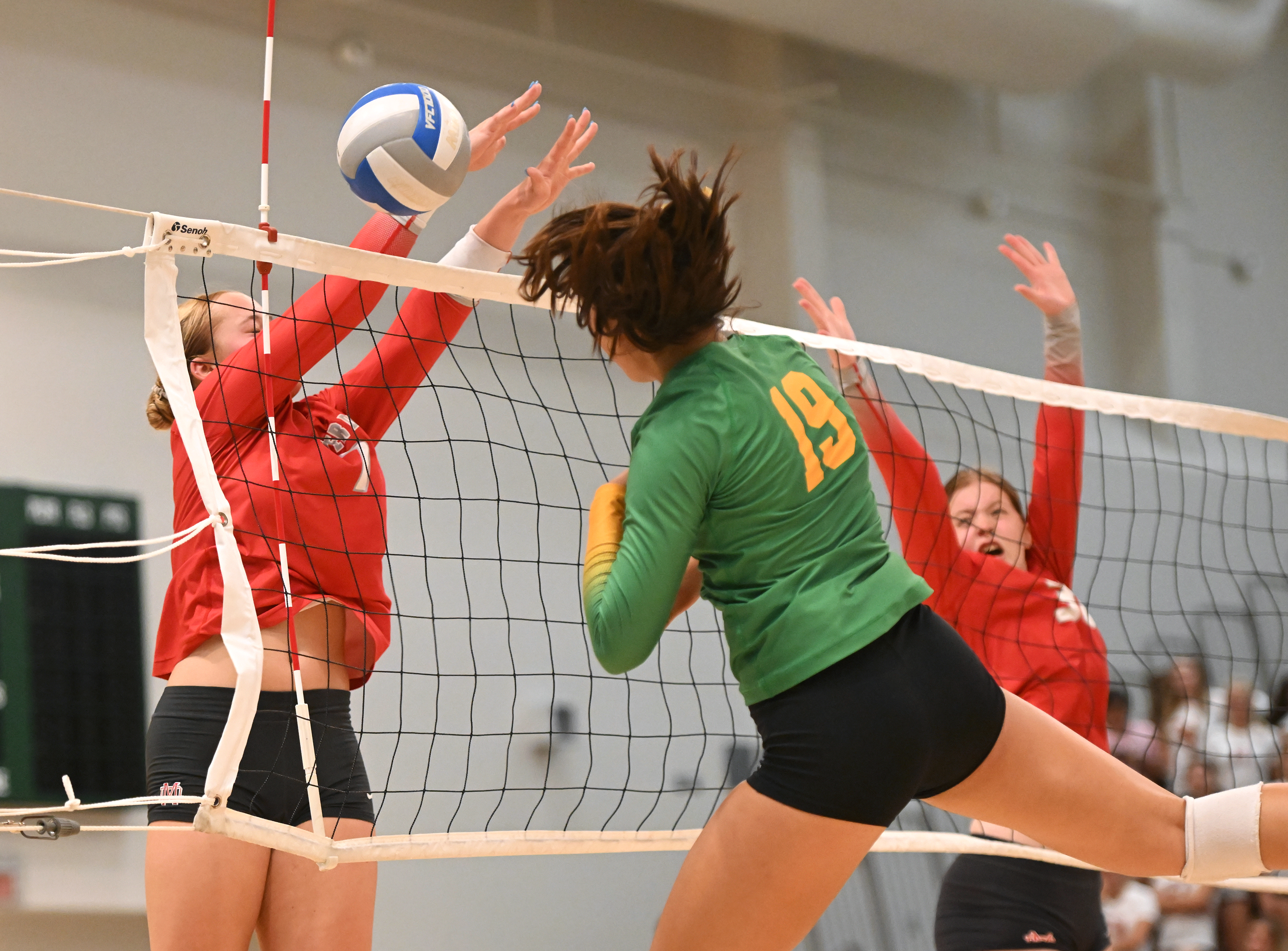 Sophomore Simone Rosion (19) hitting into a block