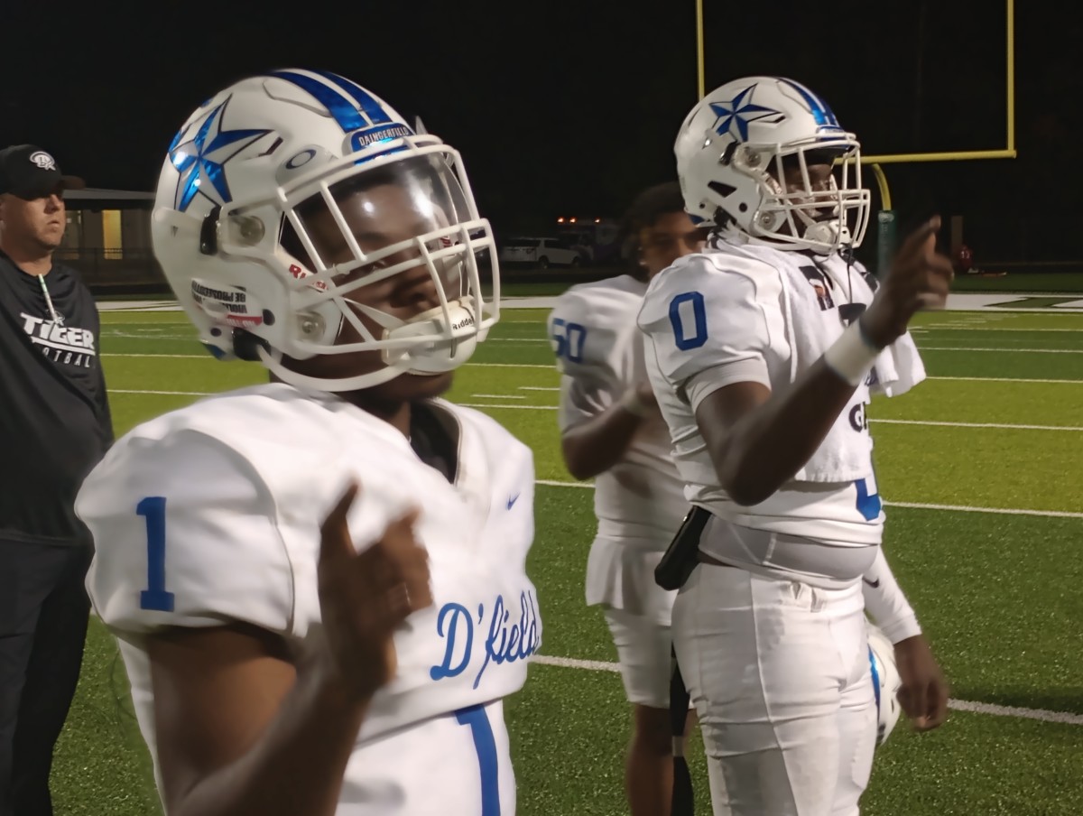 Daingerfield players Ashton Williams (left) and Chase Johnson listen to the playing of the alma mater following the Tigers' 34-17 win at Tatum on Aug. 31, 2023.