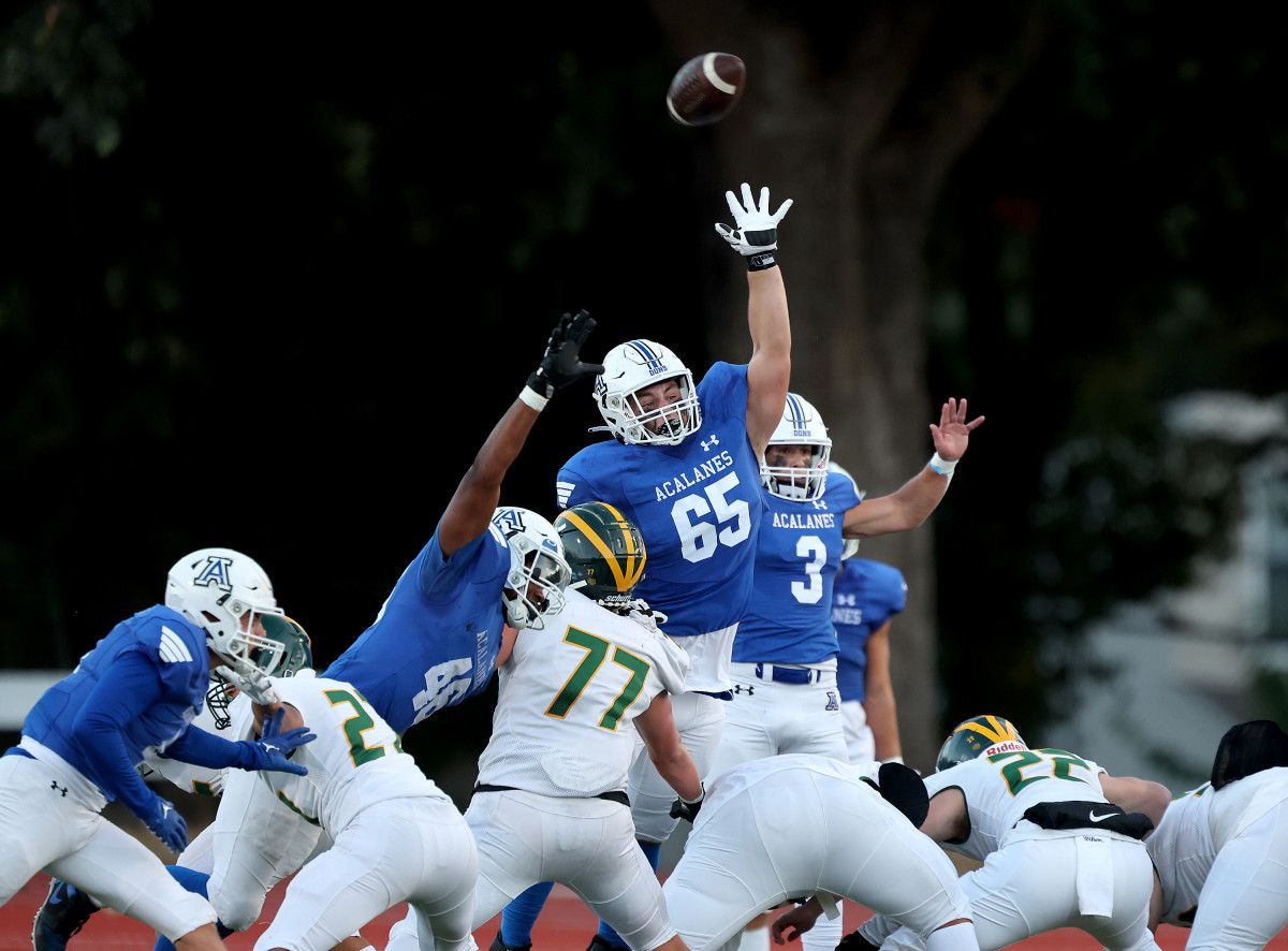 Acalanes' Brady Morrow (65) goes up high to try to block a kick by San Ramon VAlley's Austin Shelton.