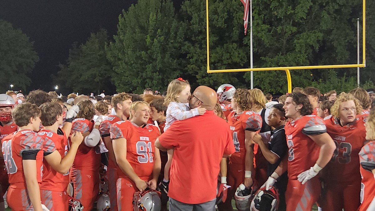 Mentor head coach Matt Gray gets a kiss from his daughter as he talks to his team after they defeated Medina on Friday night. (Photo credit: Ryan Isley)