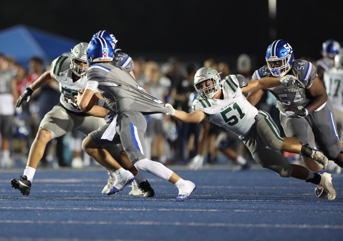 De La Salle senior Chris Biller (51) gets a hold of a Folsom jersey and eventually makes a take. Photo: Dennis Lee